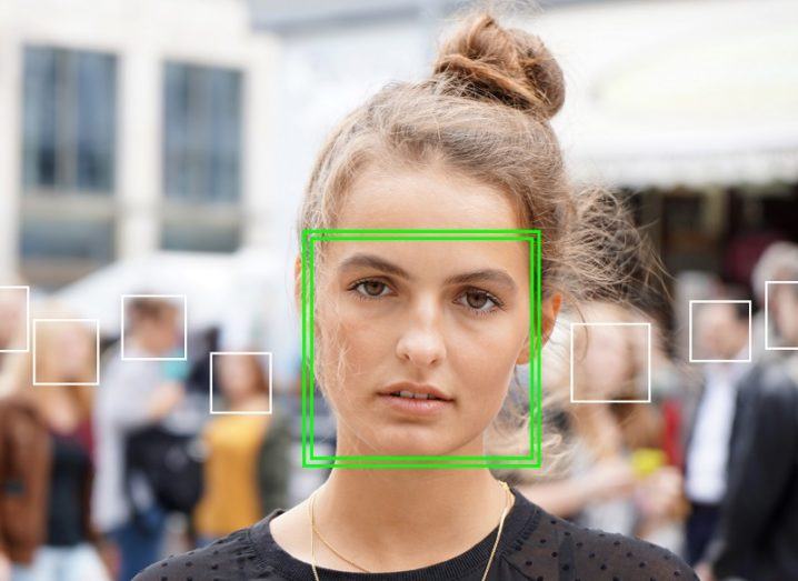 Image of a woman with a green square over her face, as if she has been picked out by facial recognition software.