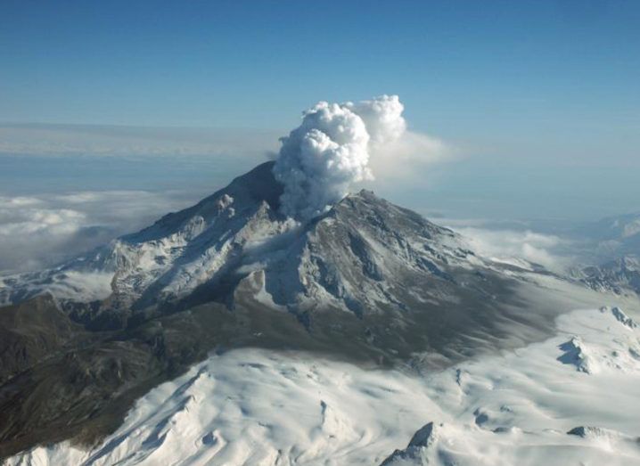 Aerial view of Mount Redoubt, Alaska, from a distance. Steam is rising from the volcano following the 2009 eruption.