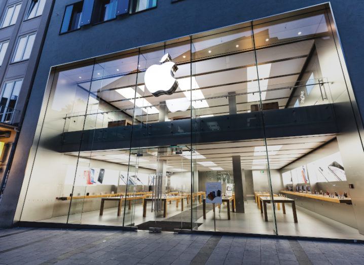 A white Apple logo on a large office with a largely glass front.