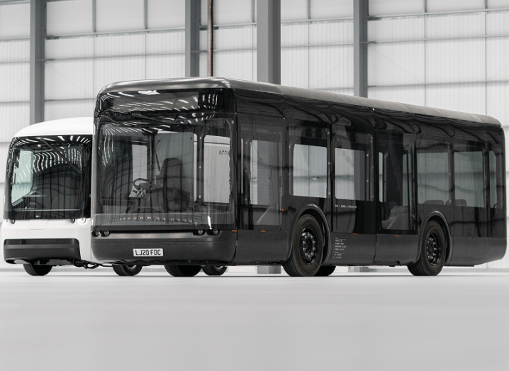 Black electric powered bus made by Arrival is sitting in a warehouse.