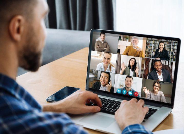 Man sitting in on a virtual meeting with colleagues on his laptop.