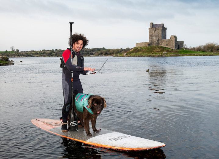 Ian Walsh with Mena from Wet Mongrel Adventures booking his place online while paddle-boarding near Dunguaire Castle, Co Galway.