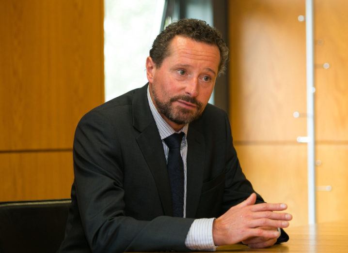 Gavin Walker sits in a suit in an office room.