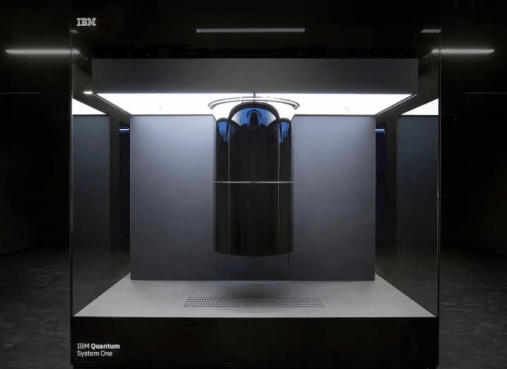 A large glass-panelled container surrounds a quantum computing system in a darkened room.