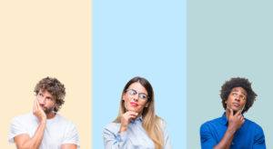 Three people are against a colourful background, with their hands up to their chins in thought.