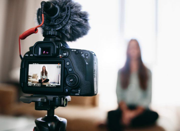 A stock image of a person talking into a video camera.