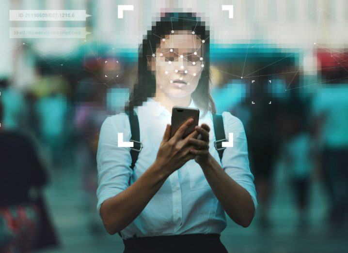 Girl in a school uniform with blurred out face holding a smartphone in a data protection themed image.