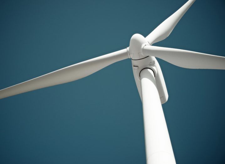 A stock image of a wind turbine against a blue sky.