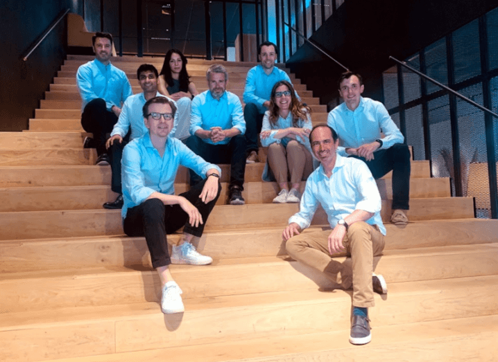 The 2150 team sitting on a wooden stairs in a group.