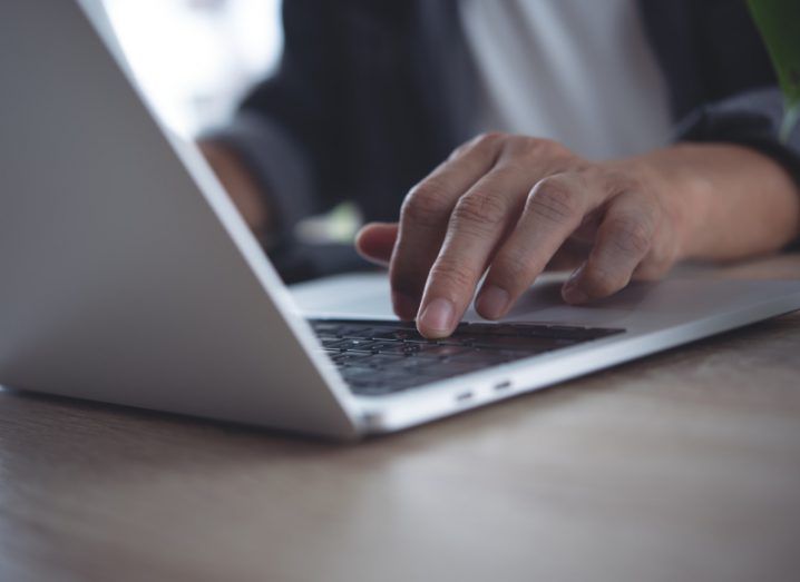 A person's hands typing on a laptop.