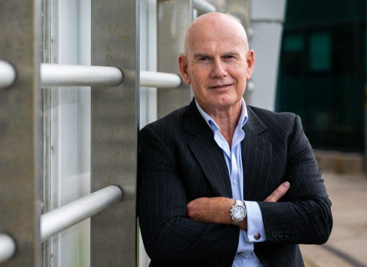 Ian Brown of Integrity360 cybersecurity company standing leaning against some railings outside with his arms folded.