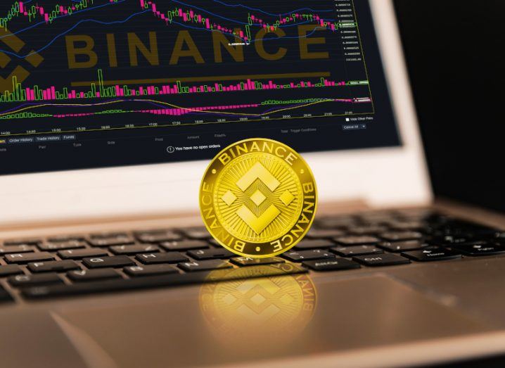 Gold coin on a laptop with the binance logo written on it.