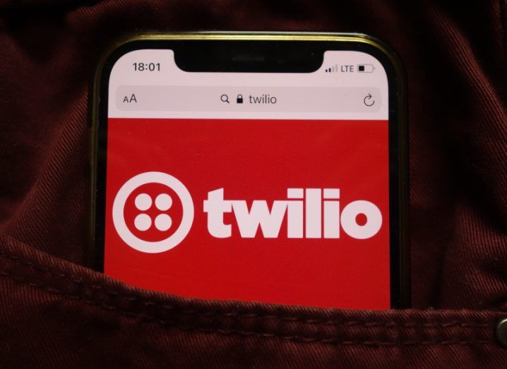 A mobile phone in a person's pocket with the Twilio logo on the screen.