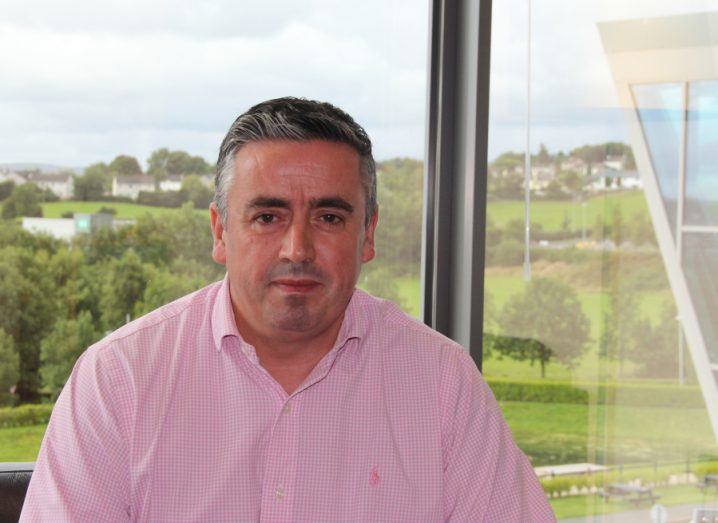 Gerard Grant, director, strategic initiatives at Tata Consultancy Services (TCS) in Ireland sitting in front of a window with a green field outside.