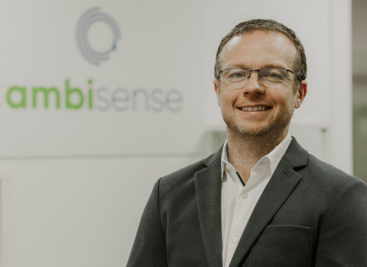 Headshot of a man wearing glasses with the Ambisense logo visible in the background.