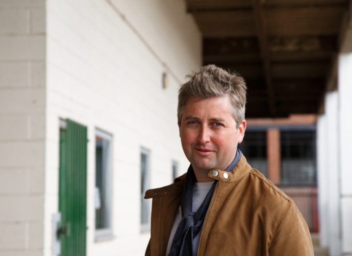 Machine Compare Marketplace CEO Ben Findlay pictured standing outside a factory building.