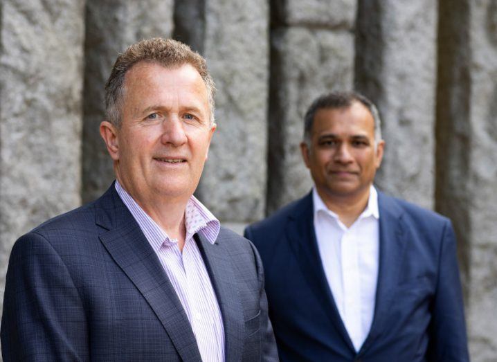 Headshot of two men wearing suits and standing next to each other.