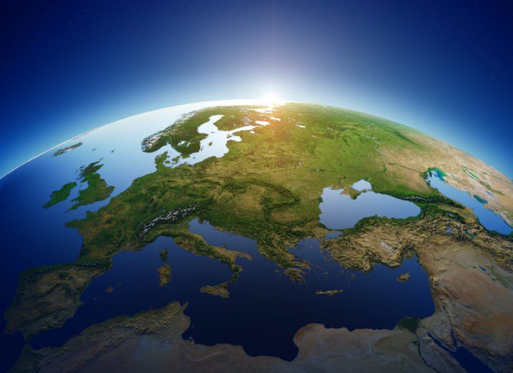 An illustration of Europe as viewed from space with the sun rising from above the horizon.