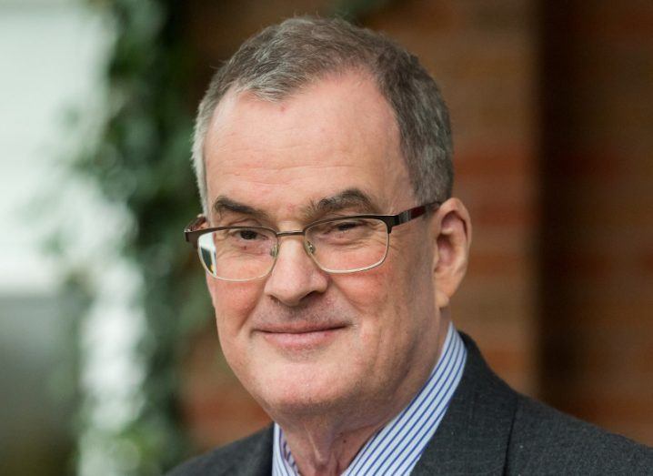 Headshot of Jon Payne, a man with short salt-and-pepper hair who wears a suit and spectacles.