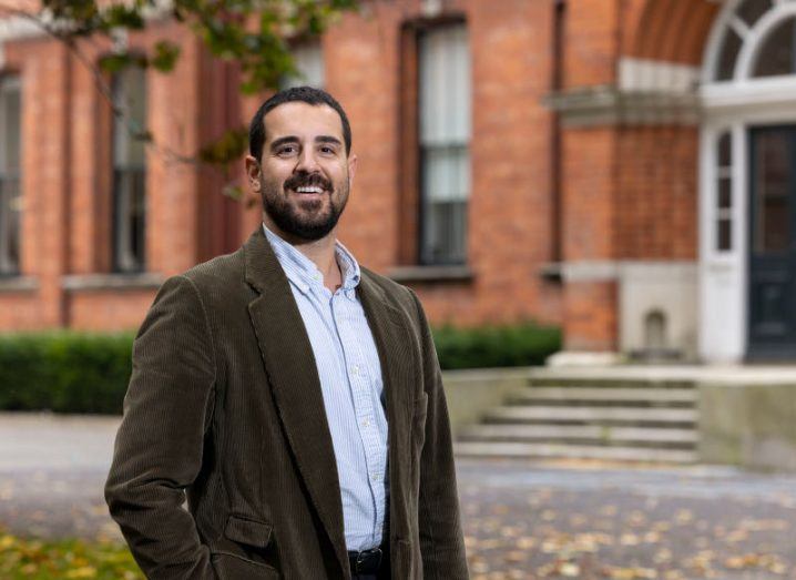 Headshot of Herman Errico, founder and CEO of Blendgate, wearing formal business attire and standing in front of a building on the grounds of the UCD Smurfit School of Business. A redbrick building can be seen behind him.