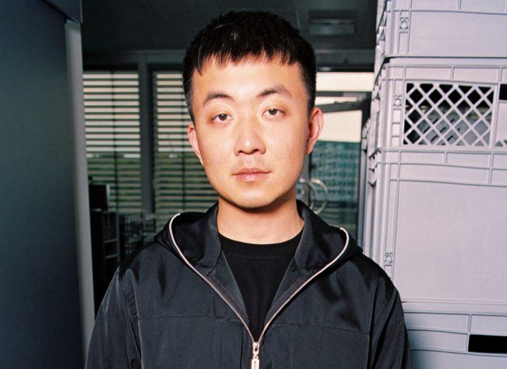 Headshot of Nothing founder and CEO Carl Pei wearing a black jacket in a small office space.