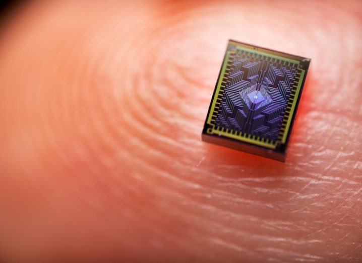 An Intel Tunnel Falls chip placed on a human finger with fingerprint visible.