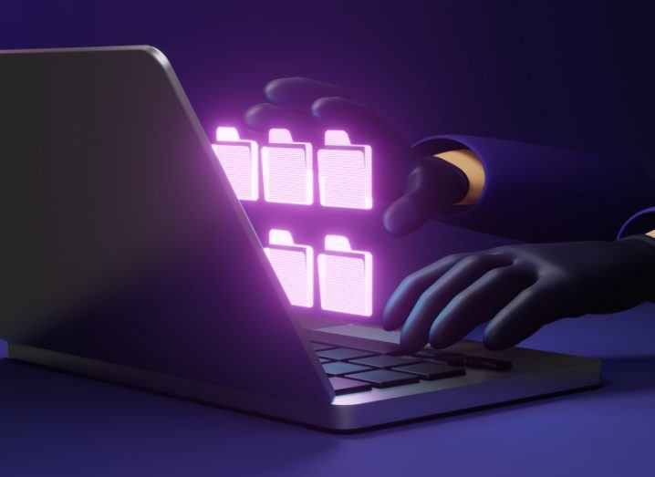 A 3D graphic of a person wearing black gloves using a laptop in the dark, with purple folders jumping out of the screen.
