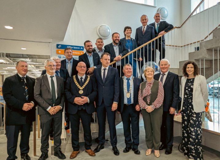 A group of men and women standing in front of and on stairs in a building. They are in the Inishowen Innovation hub in Donegal.