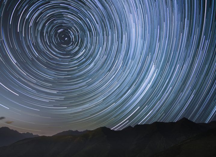 A still image of the night sky showing the movement of stars over a period of time, such that it looks like a Van Gogh painting.