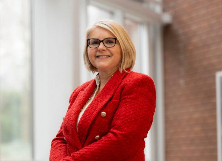 A woman with short blonde hair wearing a red blazer. She is Prof Sarah Culloty of UCC.