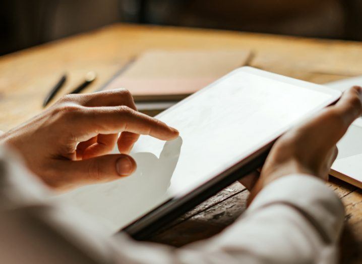 A person's hands holding a digital tablet.