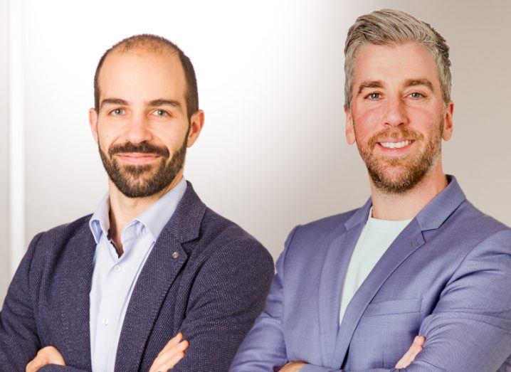 Two men in suits standing next to each other with a white wall behind them. They are the co-founders of Luma Vision.