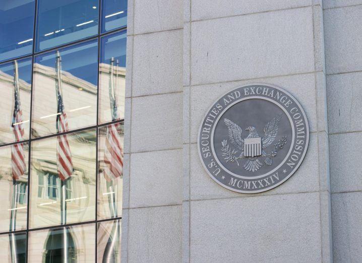 SEC logo on a building with a glass window reflect other buildings.