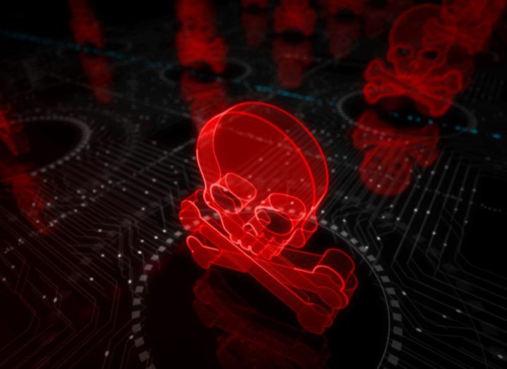 A 3D illustration of a red digital skull and crossbones, hovering above a computer interface. This represents cyberattacks.