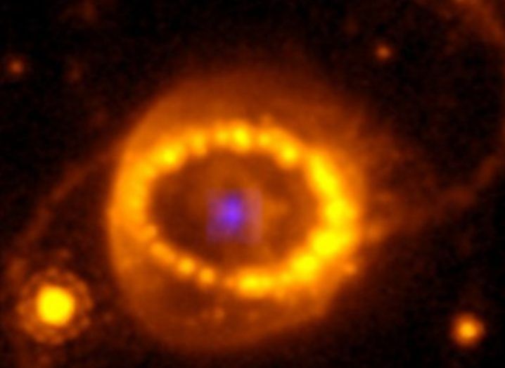 Image of the SN 1987A supernova taken by Hubble Space Telescope. Show a glowing yellow ring around a purple core.