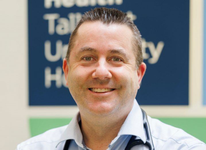 Prof Patrick Mitchell headshot with a sign behind his head where Tallaght University Hospital is written on it.