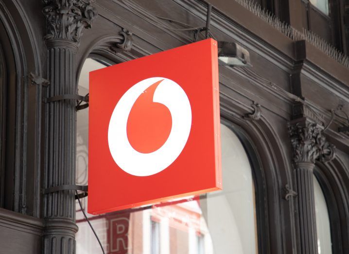Vodafone logo on a board protruding out of a building.