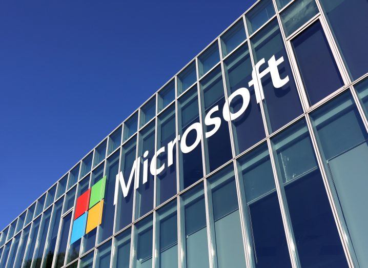 Microsoft logo on a building with the blue sky in the backdrop.