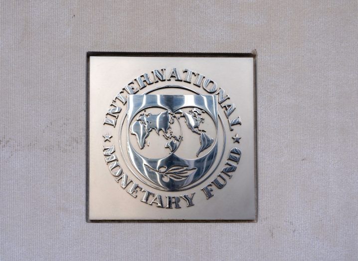 The IMF organisation logo on a grey wall.