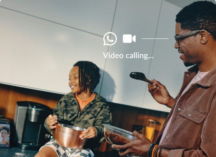 A man and a child in what appears to be a kitchen. The text "video calling" is displayed on the screen, indicating that the image is from the point of view of a person wearing the Meta Ray-Ban smart glasses.