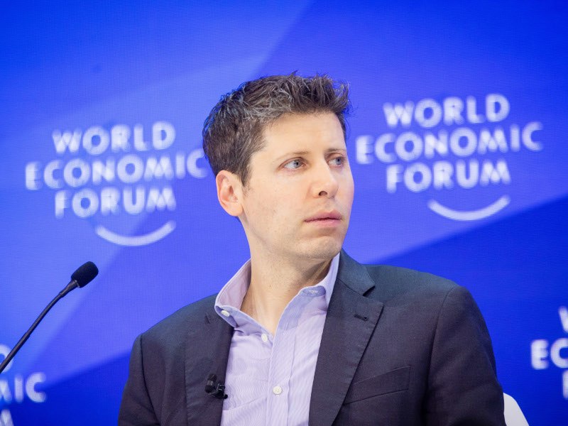 OpenAI CEO Sam Altman sitting on a stage at the World Economic Forum.
