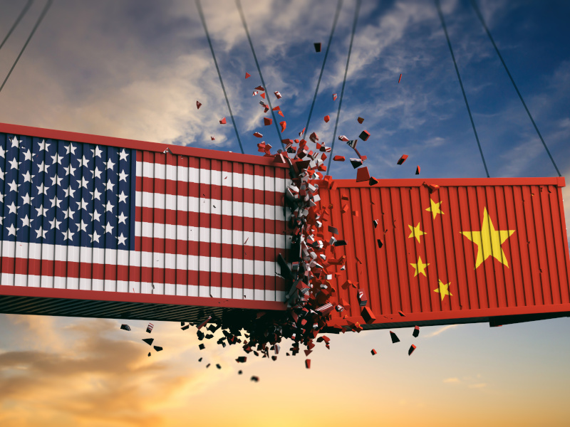 Two containers crashing into each other with the US and China flags on them. Used for the concept of US tariffs on China.