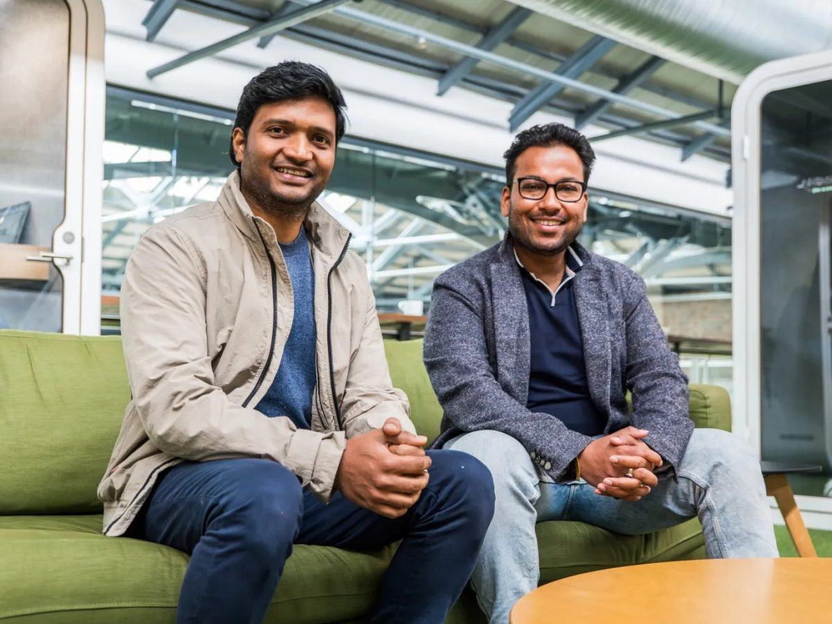 The Inspeq AI founders sitting on a couch at DogPatch Labs. They smile at the camera and both have their hands together.