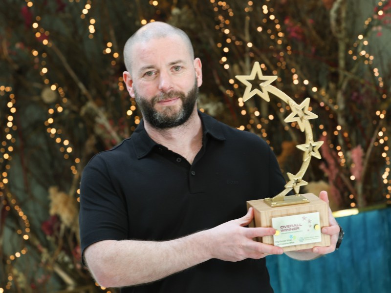 A man holding a National Enterprise Award. He is a co-founder of DreamDev Technologies.