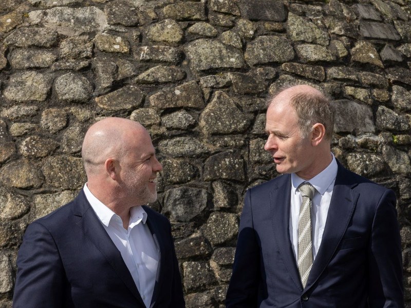 Two men standing in front of a wall. They are part of Ireland's Government and NBI, the company delivering the National Broadband Plan.