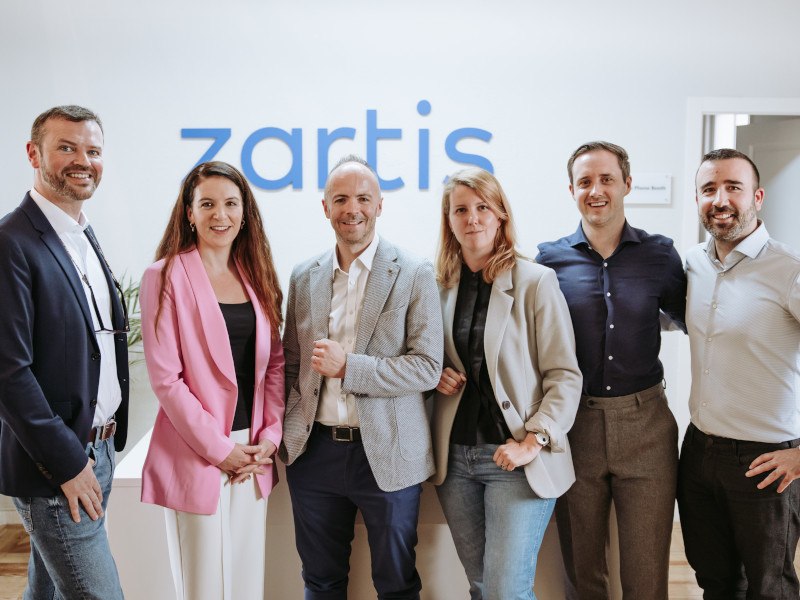 Group photo of Zartis and Development Capital executives standing next to each other.
