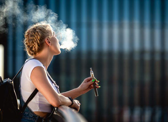 Woman vaping outside.