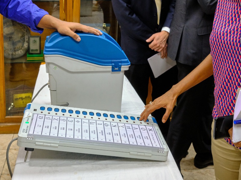 A person putting in a vote using an electronic voting machine.