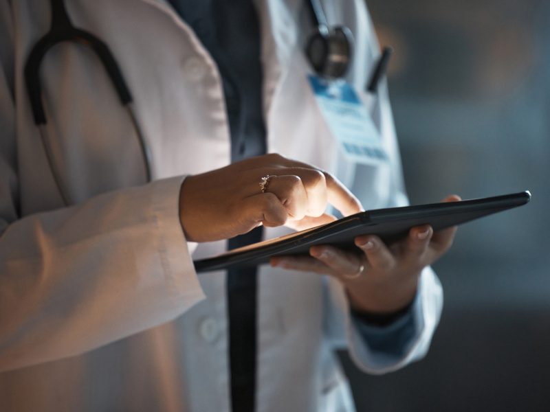 A doctor holding and using an electronic tablet. Used for the concept of electronic health records.