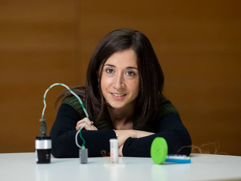 Dr Valeria Nico sits at a table surrounded by equipment for non-traditional energy generation.